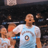 a basketball player wearing a san antonio jersey celebrates a basket