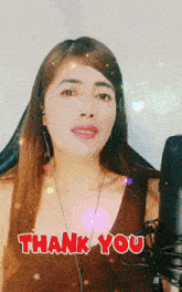 a woman singing in front of a microphone with the words thank you written on her chest