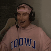 a person wearing headphones and a pink hoodie that says 100wj on it