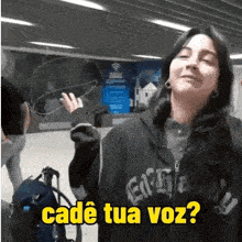 a woman wearing a black hoodie with the words cadé tua voz on it