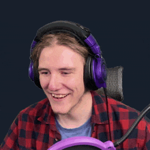 a man wearing purple headphones and a plaid shirt has the word old on his head