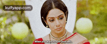 a woman in a red and white saree is standing in a field and says `` when you learn to love yourself . ''