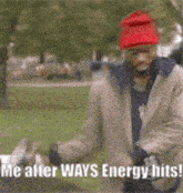 a man wearing a red hat is standing in a park and says " me after ways energy hits "