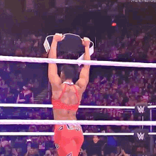 a woman is hanging upside down in a wrestling ring