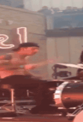 a blurry photo of a man playing drums in front of a sign that says ' e '