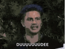 a man with blue hair is making a funny face and the words duuuuuuuudee are on the bottom
