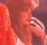 a woman is sitting in a crowd of people at a concert and looking at something .