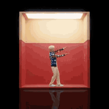 a man in a colorful sweater is standing in a red box .