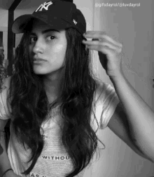 a woman wearing a ny hat and a shirt that says " without "