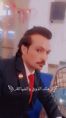 a man in a suit and tie has arabic writing on the bottom