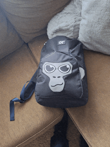 a gray backpack with a gorilla face on it is on a couch
