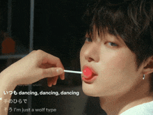 a close up of a person licking a lollipop with the words dancing dancing dancing written in the corner