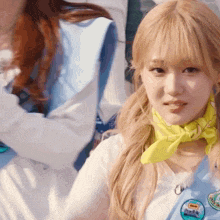 a girl wearing a yellow scarf around her neck has a badge on her jacket that says ' disney ' on it
