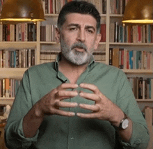 a man with a beard is wearing a green shirt