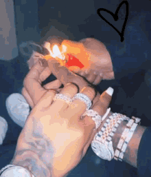 a man is lighting a cigarette with a lighter while a woman is holding his hand .