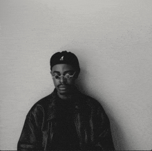 a man wearing a black kangol hat and glasses