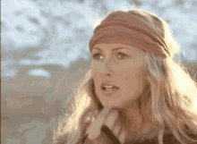 a woman wearing a pink headband is looking at the camera