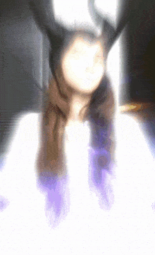 a blurry picture of a woman wearing a horned hat and a purple scarf
