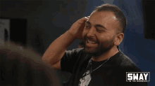 a man is smiling in front of a sway in the morning sign