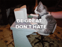 a cat is sitting at a desk with the words be great - don 't hate written on it