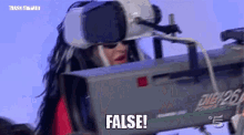 a woman wearing a virtual reality headset is holding a camera and says false .