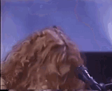 a close up of a person 's head with a microphone in the background .