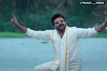 a man with his arms outstretched is wearing sunglasses and a white shirt with a yellow sash around his waist