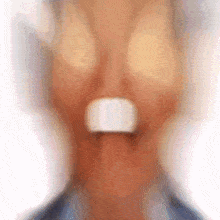 a blurry picture of a person 's face with a white circle in the middle of their mouth