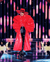 a woman in a red coat and hat is standing on a stage with t4yce tumblr in the corner