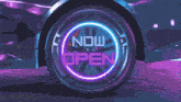 a neon sign that says now open on a wheel