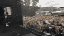 a crowd of people standing in front of a stage at a concert