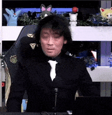 a man in a suit and tie is sitting in a chair with a microphone .