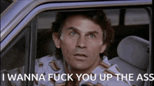 a man is sitting in a car with the words i wanna fuck you up the ass