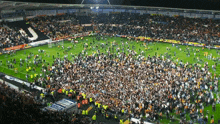 a large crowd of people are gathered on a soccer field with the letter j on the side of the field