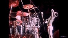 a man is standing on a stage playing a guitar and drums .