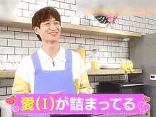 a man wearing an apron is smiling in a kitchen with a sign that says " i " on it