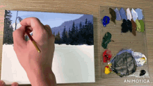 a person is painting a snowy landscape with a palette of paint behind them