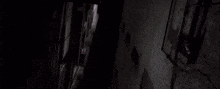 a person is standing in a dark hallway with a lot of smoke coming out of the ceiling .