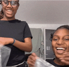 a woman wearing glasses is smiling next to another woman wearing glasses