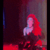 a woman with red hair is kneeling on the floor on a stage .
