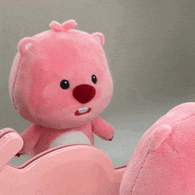 a pink stuffed animal is sitting on a pink couch