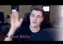 a man in a black shirt is giving a high five with the words just edits above him