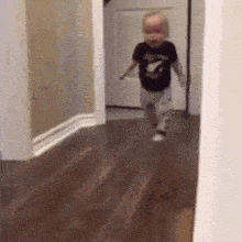 a baby is running down a hallway in a room .