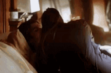 a man and woman are kissing on a bed .