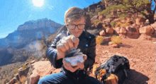 a man is sitting on a rock holding a can of something