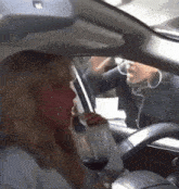 a woman driving a car with a glass of wine in her hand