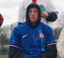 a man wearing a blue nike shirt with a chelsea logo on it
