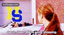 a woman is standing in front of a car that says get in , loser we 're going shopping .