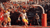 a football player with the number 4 on his jersey runs with the ball