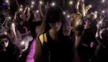 a woman in a hooded top is standing in front of a crowd of people